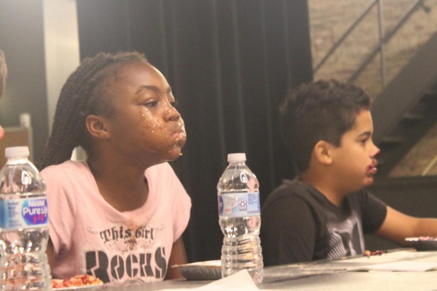 Sixth grader Nala Lindsey takes a breath after she wins the first round of GCAAs Pie Eating Contest.