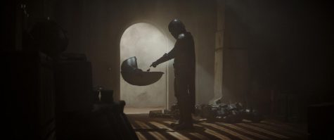 The Mandalorian reaches into the Infant’s floating crib after fighting through his captors. Photo courtesy of Disney+