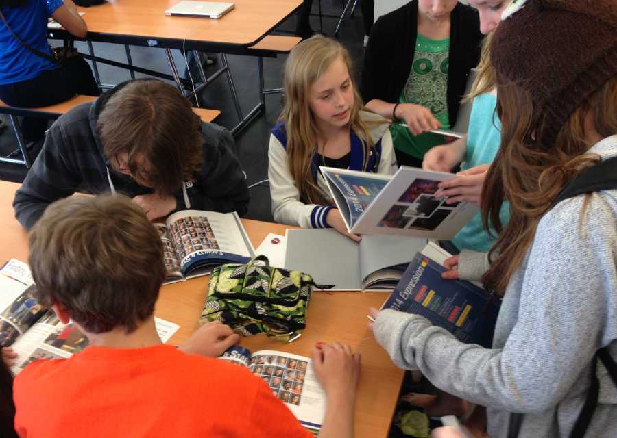 New yearbooks in hand, students gather in the north cafeteria during the 2014 Expression release party. Students who purchased books were allowed to miss part of their class to sign each others' books and celebrate the release of the first-ever yearbook on May 28, 2014.