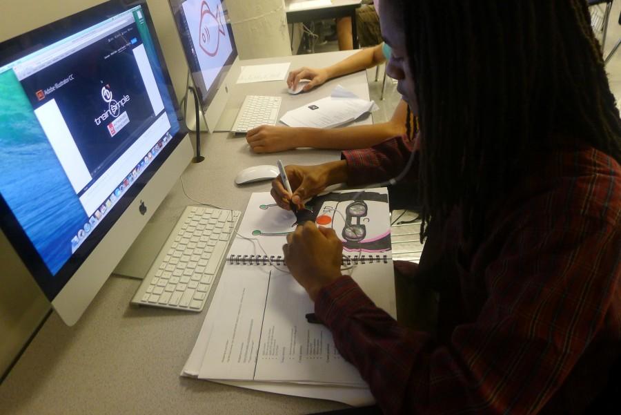 Junior Tyson Johnson works on a personal drawing while watching tutorials for Illustrator CC to learn the basics of designing.