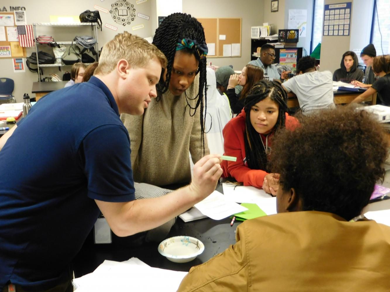 Bradford Buck demonstrates how to do a group activity to Arrius Blue, Britnee Frye, and Davion Swinson (left to right).