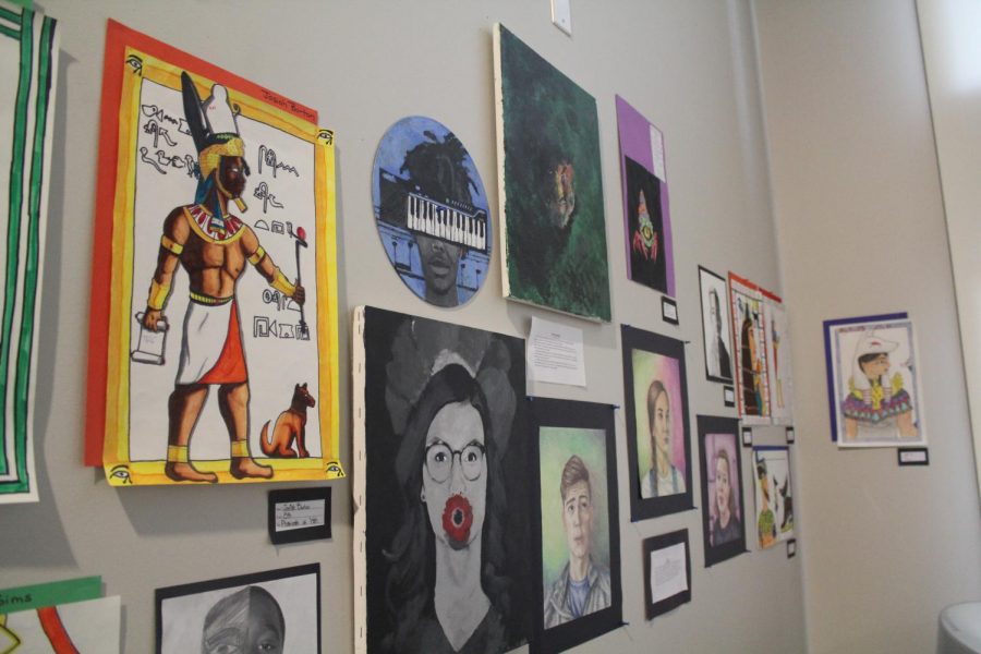 Various pieces of art hang on the wall in the mezzanine in the Sun Theater. The theme of this year's fall art show was "Identity". 