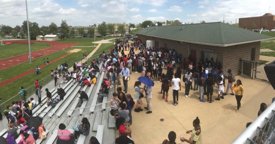 Students wait on the Cardinal Ritter football field for further instructions. This location was selected as a predesignated evacuation spot earlier in the school year.