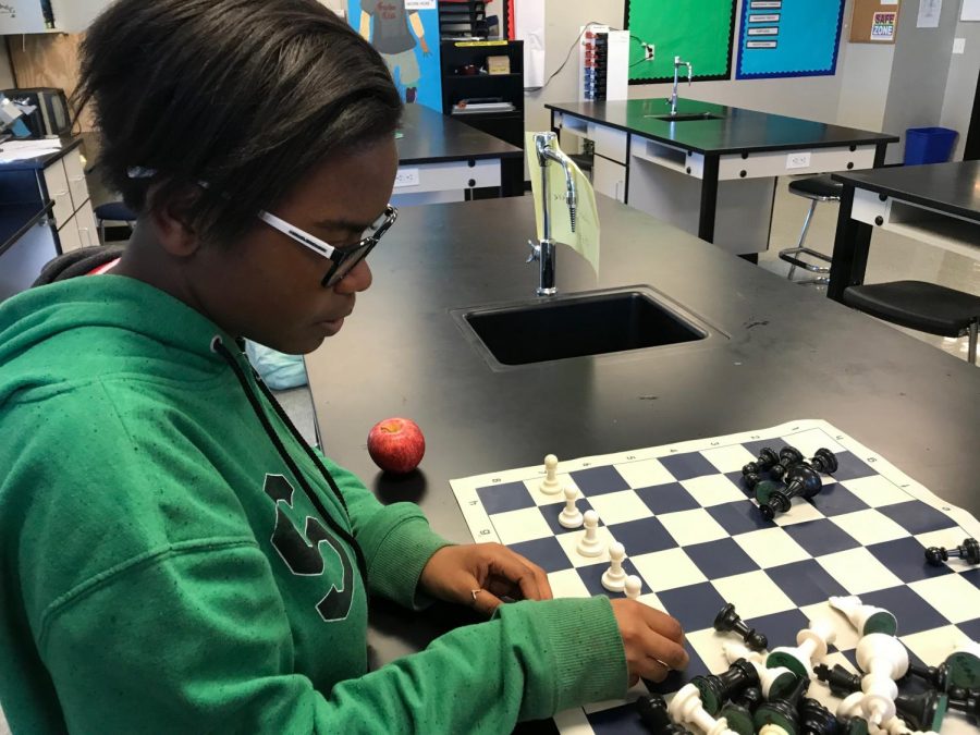 D'Ashia Miller sets up the pieces for a game of chess.