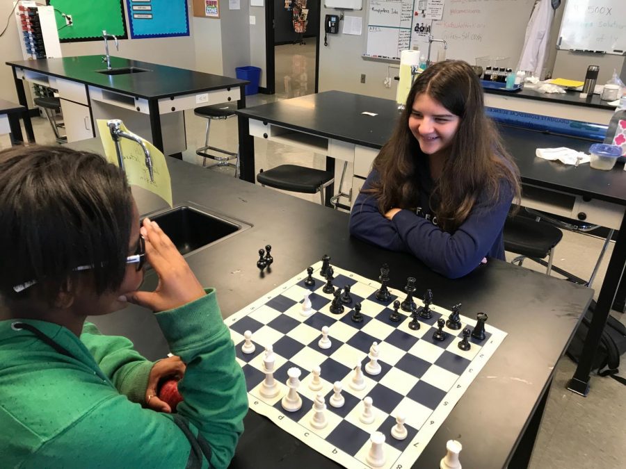 Molly Moen (right) laughs while playing chess with D'Ashia Miller (left).