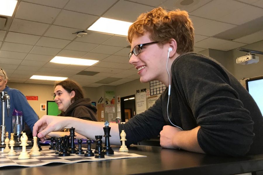 Gabe Gibert talks and laughs as he plays chess and makes his next move.