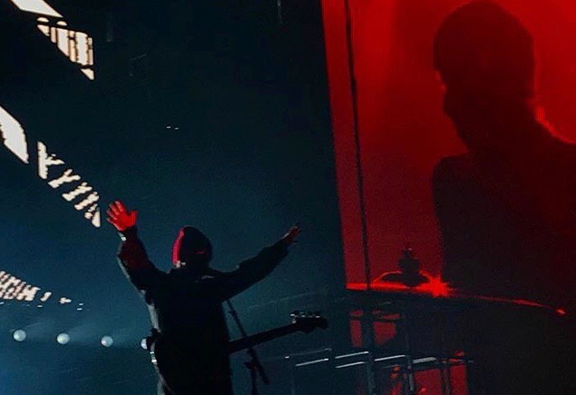 Tyler Joseph with his arms in the air as he greets the crowd. 