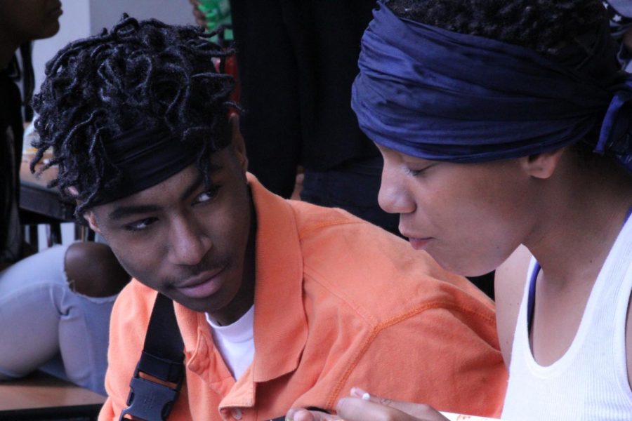 (left) Shacory Williams, sophomore, and (right) Willow Pulford, junior, discussing new head wrap dress code over lunch. 