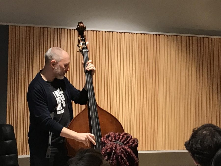 Jazz bassist Reid Anderson, playing along to, 'Big Eater', as students watch.