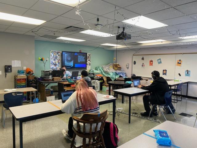 Natalie Young,  Genesis Fair,and  Darius Sims, working on book work in  Ms. Schroll's English  ll class.